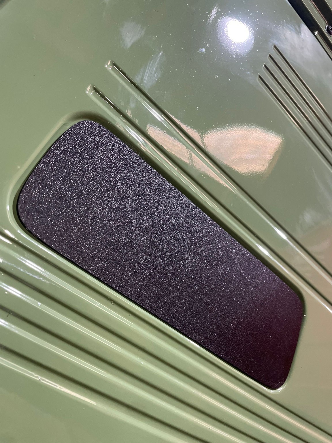A textured insert fitted into a vehicle interior panel.